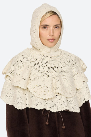 front profile model wearing with hood on Wright Poncho cream Knit poncho
Hand crocheted
Tiered layers of intricate crochet
Create a dimensional, textural silhouette
Finished with a hood
100% wool

Slip on
Relaxed fit