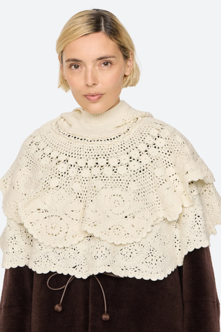 front profile model wearing without hood on Wright Poncho cream Knit poncho
Hand crocheted
Tiered layers of intricate crochet
Create a dimensional, textural silhouette
Finished with a hood
100% wool

Slip on
Relaxed fit