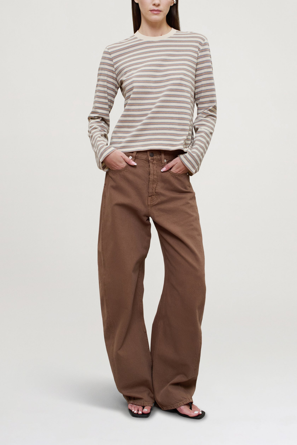 front profile model wearing Wynn Long Sleeve Stripe T- Shirt Apricot Stripe 
Relaxed boxy fit
Subtle cropped length
Roomy sleeves
Slight taper at waist
Shifted side seams give a tailored look
Solid binding at neckline
Subtle tonal logo embroidery at hip
100% Cotton