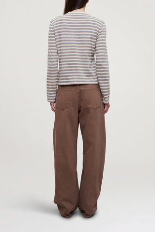 back profile model wearing Wynn Long Sleeve Stripe T- Shirt Apricot Stripe 
Relaxed boxy fit
Subtle cropped length
Roomy sleeves
Slight taper at waist
Shifted side seams give a tailored look
Solid binding at neckline
Subtle tonal logo embroidery at hip
100% Cotton