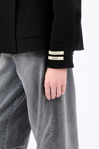close up cuff tag detail for  Double Face Double Breast Jacket black Double-breasted jacket
Classic collar
Slightly flared fit
Patch flap pockets
Sleeves with cuffs and buttons
Back yoke with seam detail
Material: 80% wool, 20% cashmere