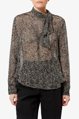 front proflile model wearing Leona Printed Top black ecru Lightweight printed muslin blouse
Stand-up collar with pussy bow
Long sleeves with buttoned cuffs
Asymmetrical opening