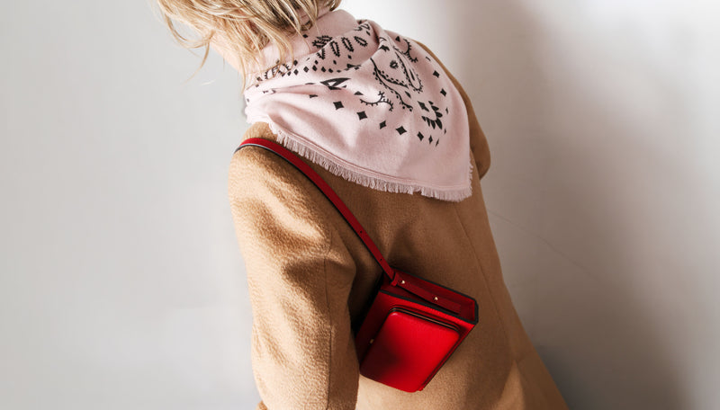 model wearing pink bandana kujten scarf, camel coat and red leather bag
