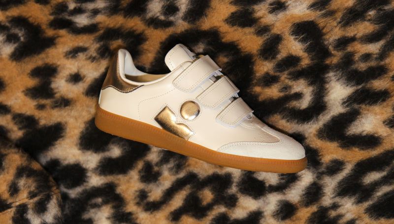 side profile leather beige sneaker with gold logo accent and leopard print background